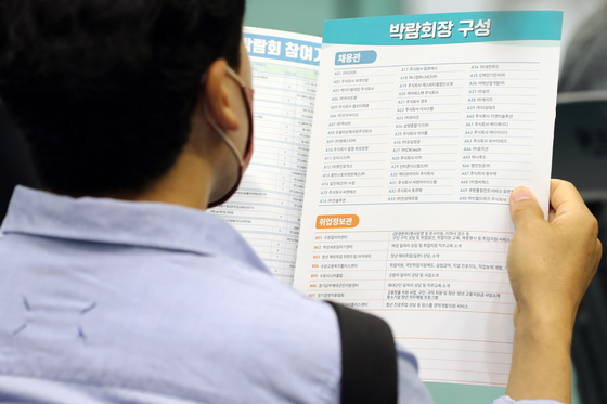 An applicant looking at job openings at a job fair in Suwon on June 9. [YONHAP]