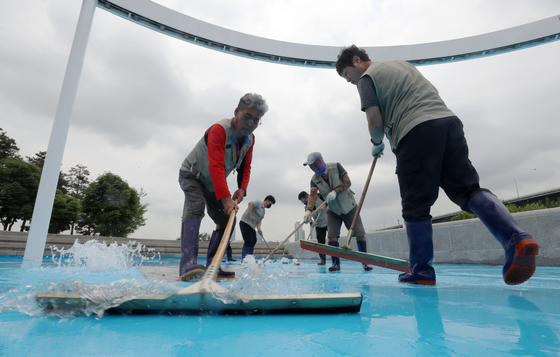 Workers clean a pool on the bank of the Han River in Seoul on Thursday. All outdoor pools on the banks of the Han River will open to the public from June 24.   [NEWS1]