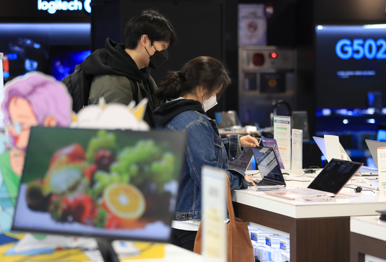 Customers look at laptops displayed at a discount mart in Wangsimni, eastern Seoul. [YONHAP]