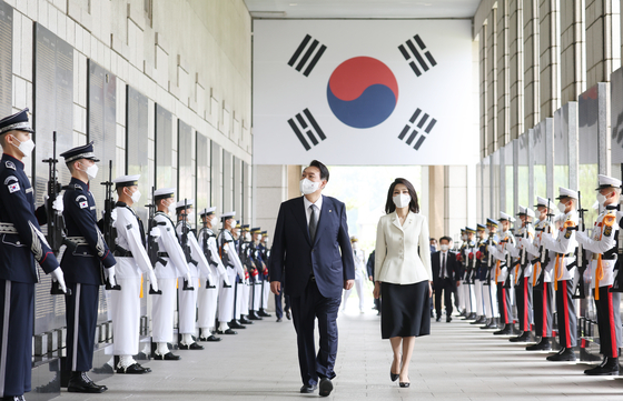 President Yoon Suk-yeol, left, and first lady Kim Keon-hee walk past soldiers lined up at the War Memorial of Korea in Yongsan District, central Seoul, on June 17. [YONHAP]