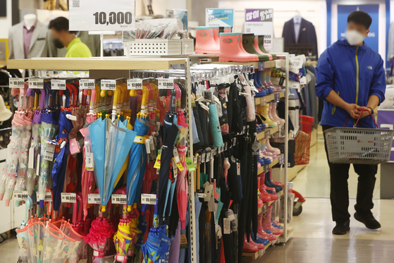 Umbrellas and rain boots are sold at a discount mart in Seoul on Monday ahead of the rainy season in Korea. [YONHAP]