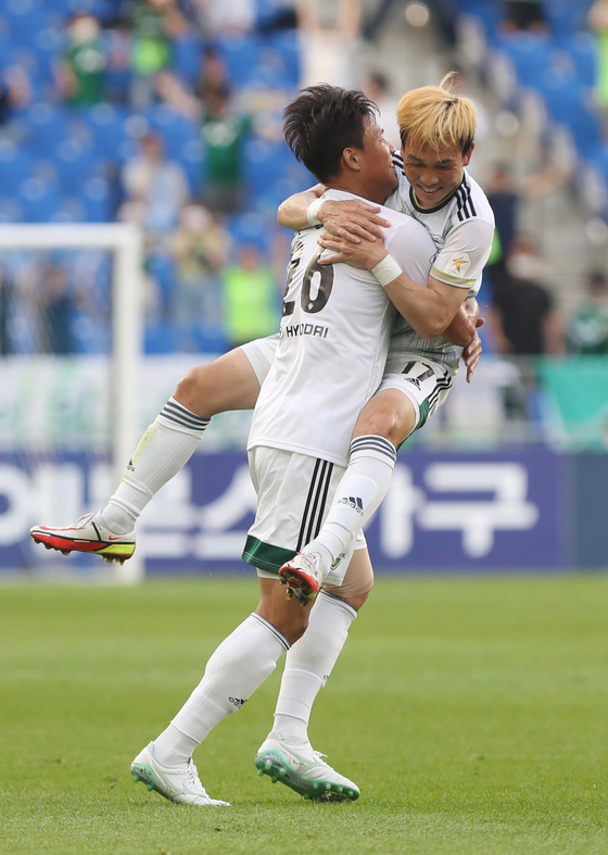 Jun Amano of Jeonbuk Hyundai, right celebrates with Hong Jung-ho after scoring for Jeonbuk during a match against Ulsan Hyundai at Munsu Football Stadium in Ulsan on Sunday. [YONHAP]