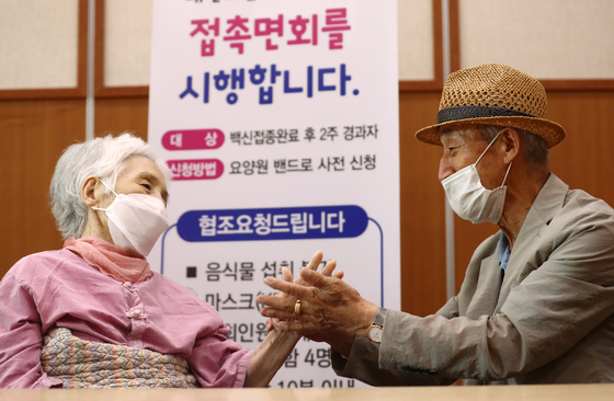 A husband greets his hospitalized wife at a nursing home in Daejeon on Monday, when people were allowed to visit such facilities nationwide regardless of their vaccination status. [NEWS1]