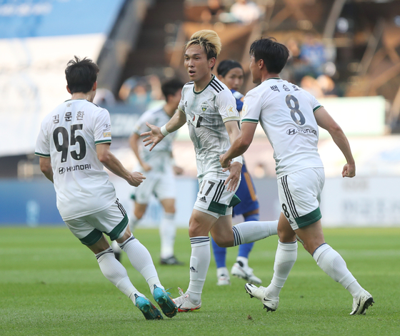 Jun Amano of Jeonbuk Hyundai, center, celebrates scoring Jeonbuk's second goal of the match against Ulsan Hyundai at Munsu Football Stadium in Ulsan on Sunday. [YONHAP]