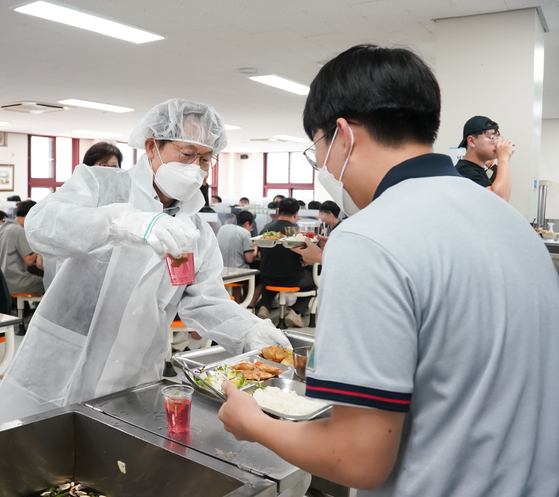 Cho Hee-yeon, superintendent of the Seoul Metropolitan Office of Education, serves school lunches at Seoul High School in Seocho District, southern Seoul, on June 17. [YONHAP]