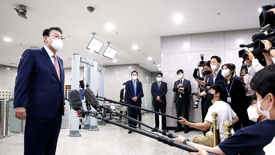 President Yoon Suk-yeol answers reporters’ questions on whether he plans to attend a North Atlantic Treaty Organization (NATO) summit in Spain later this month, on his way into the presidential office in Yongsan District, central Seoul, Thursday morning. [JOINT PRESS CORPS]