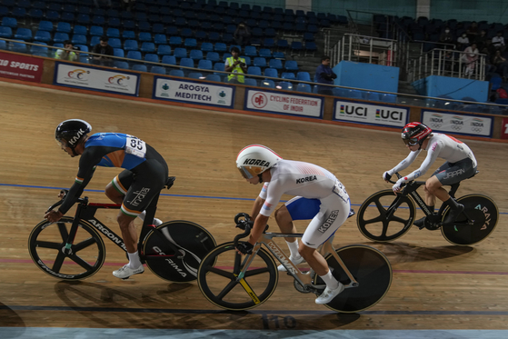 Sekhon Harashveer of India, left, Kim Eu-ro of Korea, center, and Kojima Maoki of Japan compete in the 30-kilometer (18.6-mile) Men Elite Points Race at the Asia Track Cycling Championship in New Delhi, India on Tuesday. Kim took silver in the event for Korea. [AP/YONHAP]