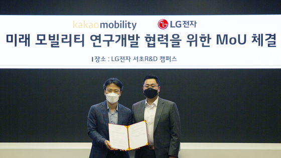 LG Electronics Chief Technology Officer (CTO) Kim Byoung-hoon and Kakao Mobility CTO Yoo Seung-il pose for photo during a signing ceremony held in Yangjae, southern Seoul, Friday. [LG ELECTRONICS, KAKAO MOBILITY]