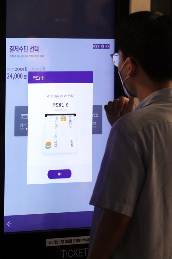 A customer buys tickets using an electronic screen at the Megabox Coex branch in southern Seoul on Wednesday. The cinema franchise said on the same day that it will raise the price of its regular tickets by 1,000 won (77 cents) and 2,000 won for more luxurious theaters with bigger seats, starting July 4. [NEWS1]