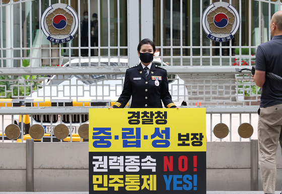 A police officer holds a one-person rally in protest of the Interior Ministry’s plan to establish a police bureau tightening its grip over the police in front of the government complex in central Seoul Thursday. [YONHAP]