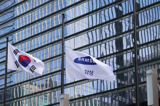 The Taegeukgi, or Korean national flag, and the Samsung Electronics flag fly outside the company’s office in Seocho District, southern Seoul. [JOINT PRESS CORPS]