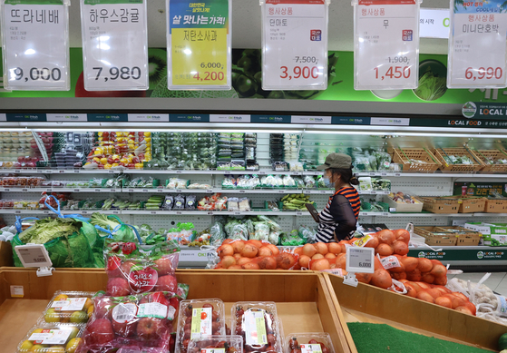 A customer shops for groceries at a store in Seoul on Sunday. According to Statistics Korea, the average monthly meal costs for a family of four in the first quarter was 1.07 million won, up 9.7 percent year-on-year from 972,286 won. [YONHAP] 
