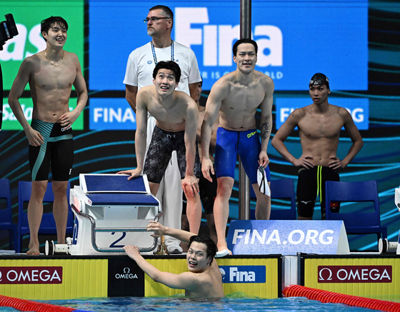 Standing from left: Kim woo-min, Hwang Sun-woo and Lee yoo-yeon congratulate Lee Ho-joon after he completes the final lap of the men's 800-meter freestyle relay final at the Budapest 2022 World Aquatics Championships at Duna Arena in Budapest on Thursday. [AFP/YONHAP]