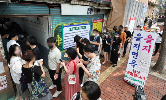 People line up outside Eulji Myeonok in Jung District, central Seoul, on Saturday to get one last bowl of naengmyeon (cold noodles). The restaurant served its last meals on Saturday after 37 years of service as the area will be developed. [YONHAP]