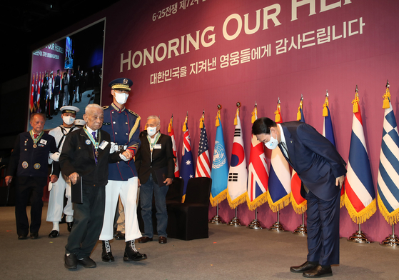 Yoon, far right, bows down in respect to the 1950-53 Korean War veterans as they exit the stage after a medal ceremony at an event in Seoul on Friday to honor their valor and sacrifice. [NEWS1]
