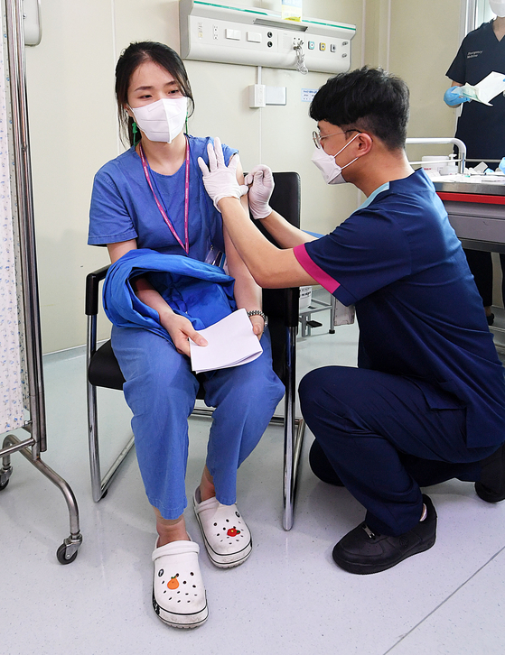 A health care worker receives a monkeypox vaccine at the National Medical Center in Jung District, central Seoul, Monday. [YONHAP] 