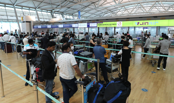 Travelers wait to get checked in at Incheon International Airport on Sunday. [NEWS1]