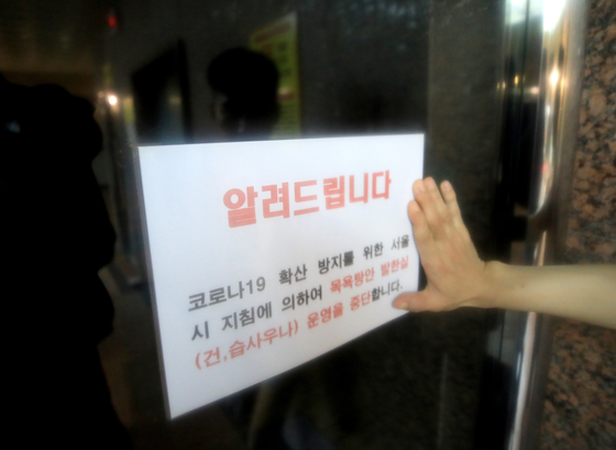 A closure sign is on the door of a bathhouse in Seoul on Nov. 30, 2020 as part of the government's social distancing restrictions during the third wave of the pandemic. [NEWS1]