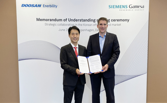 Doosan Enerbility Executive Vice President Sohn Seung-woo, left, and Siemens Gamesa offshore business unit CEO Marc Becker pose during a signing ceremony in Copenhagen. [DOOSAN ENERBILITY]
