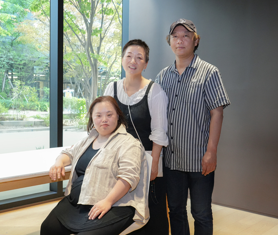 From left, artist and actor Jung Eun-hye, producer Jang Che Hyun-sil and director Seo Dong-il behind the documentary "Please Make Me Look Pretty" pose for a photo at a cafe in Sangam-dong, western Seoul, on Wednesday. [JEON TAE-GYU]