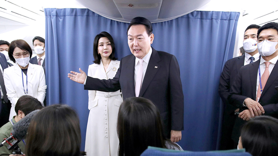 President Yoon Suk-yeol and first lady Kim Keon-hee greet presidential office reporters aboard Air Force One en route to Madrid for the NATO Summit Monday. [JOINT PRESS CORPS]