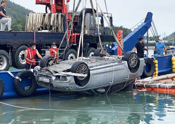 A vehicle belonging to the family of missing child Cho Yoo-na is lifted out of the water near Songgok Harbor in Wando, South Jeolla on Wednesday morning. [YONHAP]