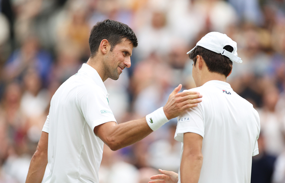Serbia's Novak Djokovic greets Kwon Soon-woo, right, at the net after winning their men's first round singles match on day one of Wimbledon on Centre Court at the All England Lawn Tennis and Croquet Club in London on Monday. [XINHUA/YONHAP]
