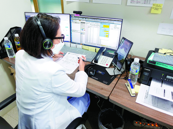 A doctor in Gangnam, southern Seoul, consults a Covid-19 patient through a video call in March, when virus cases peaked. [HANA ENT HOSPITAL]