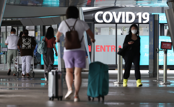 Travelers pass by a Covid-19 testing center at Incheon International Airport on Wednesday. On Wednesday, imported cases surpassed 200 for the first time in nearly five months. [YONHAP]