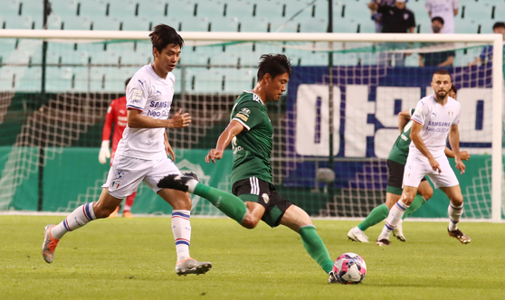 Hong Jung-ho of Jeonbuk Hyundai Motors, center, plays the ball against the Suwon Samsung Bluewings in quarterfinals of the 2022 FA Cup on Wednesday at Jeonju World Cup Stadium in Jeonju, North Jeolla. [YONHAP]