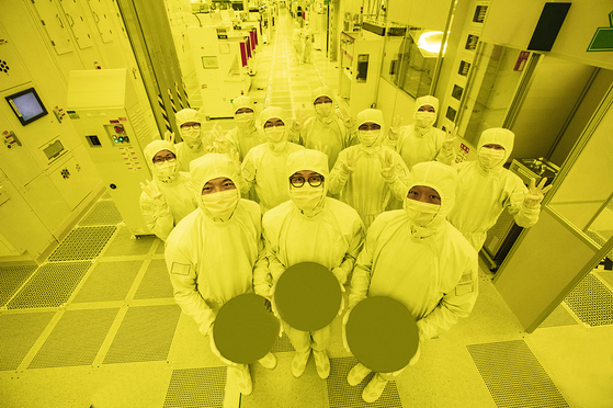 Engineers at Samsung Electronics hold 3-nanomter wafers at the company's factory. [SAMSUNG ELECTRONICS]