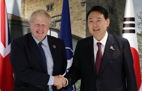 President Yoon Suk-yeol, right, and British Prime Minister Boris Johnson meet on the sidelines of the NATO Summit in Madrid, Spain on Thursday. [JOINT PRESS CORPS] 