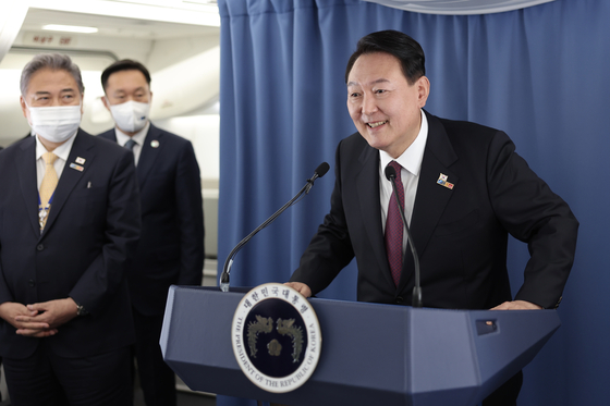 President Yoon Suk-yeol speaks to reporters in a press conference aboard Air Force One en route to Seoul from Madrid after concluding a five-day trip to Spain to attend a NATO summit. [YONHAP]