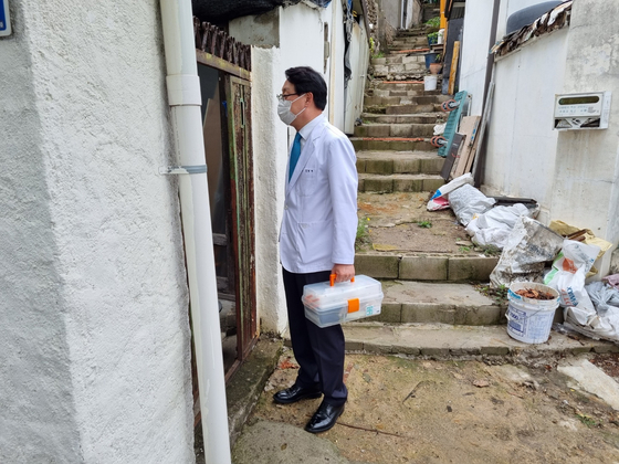 Jang Hyeon-jae, director at Fatima Clinic, enters a patient's house for home health care in Nowon District, northern Seoul, on June 16. [YI WOO-LIM]