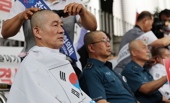 Chiefs of regional police officers' associations have their heads shaved outside the National Police Agency's headquarters in Seodaemun District, central Seoul on Monday to protest the Interior Ministry's plans to establish a police affairs bureau to oversee the police investigations. [YONHAP]