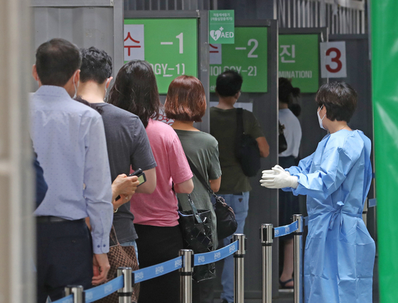 People line up to get tested at a Covid-19 screening clinic in Yongsan District, central Seoul, on Tuesday, as the country saw its largest infection count in 40 days. [NEWS1]
