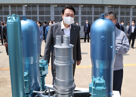 President Yoon Suk-yeol looking at a miniture model of a APR1400 nuclear reactor during his visit to Doosan Enerbility in Changwon, South Gyeongsang, on June 22. [YONHAP] 