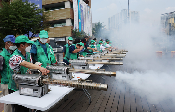 Workers from the Seongbuk District Office in Seoul learn how to operate fumigators to spray insect repellant on Tuesday. Swarms of a new kind of small fly nicknamed the Love Bug, because it is frequently seen mating, have appeared in Goyang, Gyeonggi, and in Seoul recently. [NEWS1]