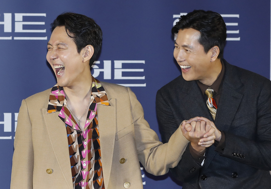 Director and actor Lee Jung-jae and co-star Jung Woo-sung hold hands at the local press event at the Megabox Seongsu branch Tuesday to promote their film "Hunt," set to be released in local theaters on Aug. 10. [NEWS1]
