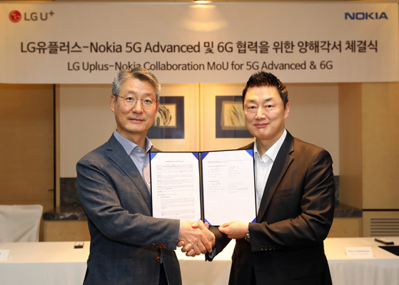 Kwon Jun-hyuk, left, head of LG U+ network unit, and Ahn Tae-ho, head of Nokia Korea, pose for photo during a signing ceremony held in Gwanghwamun, central Seoul. [LG U+]