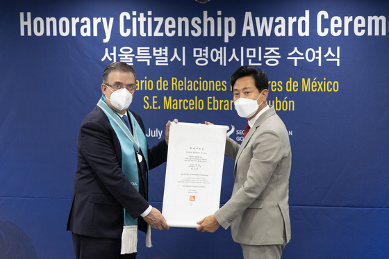 Mexican Foreign Secretary Marcelo Ebrard, left, receives honorary citizenship of Seoul from Mayor Oh Se-hoon, right, at Seoul City Hall on Wednesday, for his contribution to the friendly relations between Seoul and Mexico City. Ebrard was mayor of Mexico City, one of Seoul’s sister cities since 1992. [YONHAP] 