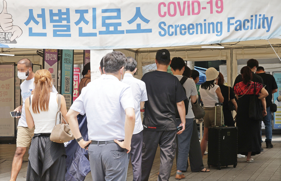 People line up to get a Covid-19 test at a screening clinic in Yongsan District, central Seoul, on Wednesday, when the country reported the largest daily tally in 42 days of nearly 20,000 cases. [YONHAP]