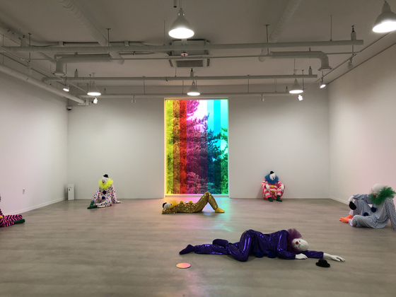 Some of the clowns from Rondinone's "Vocabulary of Soltitude" (2016) and the colorful glass panel "Love Invents Us" (1999/2022) [SHIN MIN-HEE]