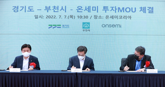 Gyeonggi Governor Kim Dong-yeon, center, signs an agreement to build onsemi's research center and manufacutring facility in Bucheon, Gyeonggi with Wei-Chung Wang, executive vice president at onsemi, on the right, on Thursday. [GYEONGGI PROVINCIAL GOVERNMENT] 