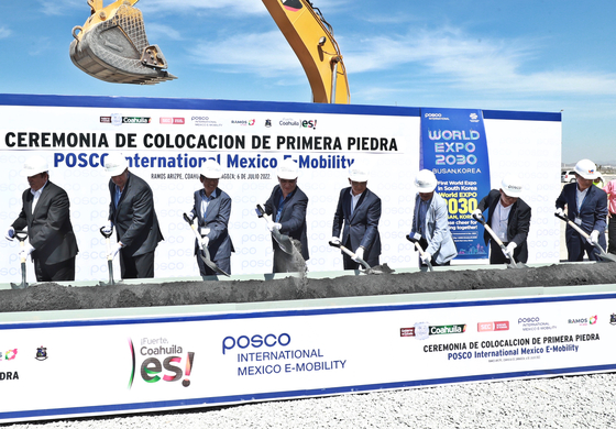 Joo Si-bo, fifth from left, president of Posco International, turns a shovel during a groundbreaking ceremony for the construction of an EV component factory in Mexico on Wednesday. [POSCO INTERNATIONAL]