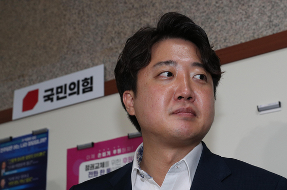 Lee Jun-seok, chair of the People Power Party, responds to questions from the press after testifying to the party's ethics committee early Friday morning. [KIM SANG-SEON] 
