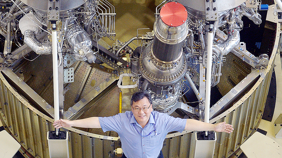Han Young-min, who developed the liquid-fuel engines for Korea's first domestically-developed rocket Nuri (KSLV-II), poses in front of the first stage engine of Nuri at the Korea Aerospace Research Institute in Daejeon on June 24. [KIM SUNG-TAE]