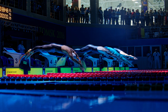 Monofins를 착용한 수영자들은 World Games에서 제공한 이 스톡 이미지에서 레이스가 시작될 때 수영장으로 다이빙합니다. [WORLD GAMES]