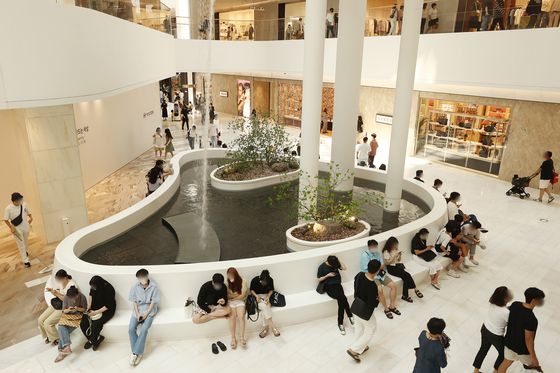 Customers at a department store in Seoul take a rest from the heat on Sunday. [YONHAP]
