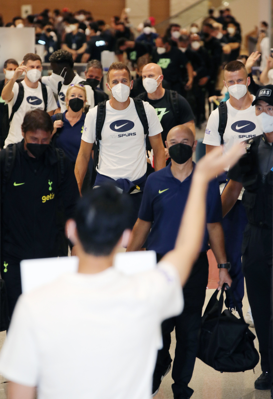 Head coach Antonio Conte, front left, leads Harry Kane, center, and the Tottenham Hotspur squad and support staff into the Incheon International Airport Arrivals Hall in Incheon on Sunday. The team, which will play two exhibition games in Korea over the next week, was greeted at the airport by hundreds of fans and Korean forward Son Heung-min, pictured in the foreground, who was already in Korea for the summer break. Son met the team holding a sign that said “Welcome to Seoul.” [YONHAP]